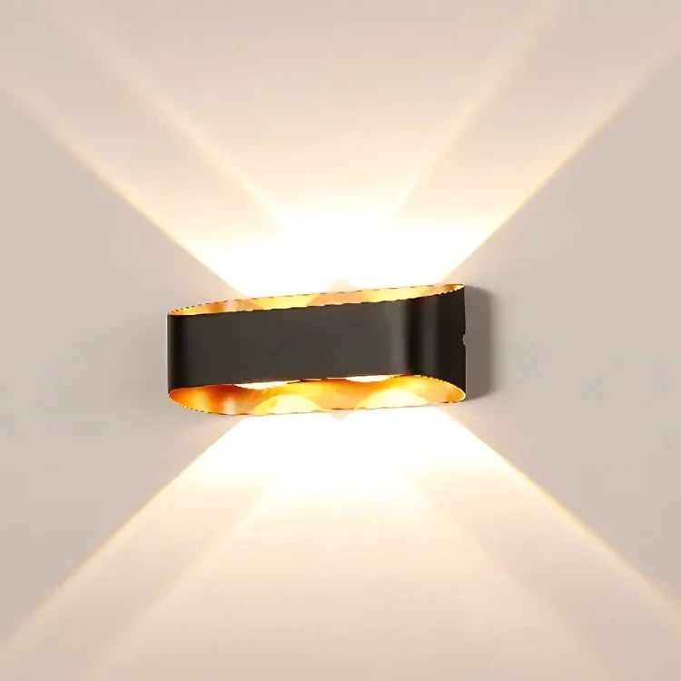Modern black and gold wall sconce with warm ambient lighting for contemporary interior decor