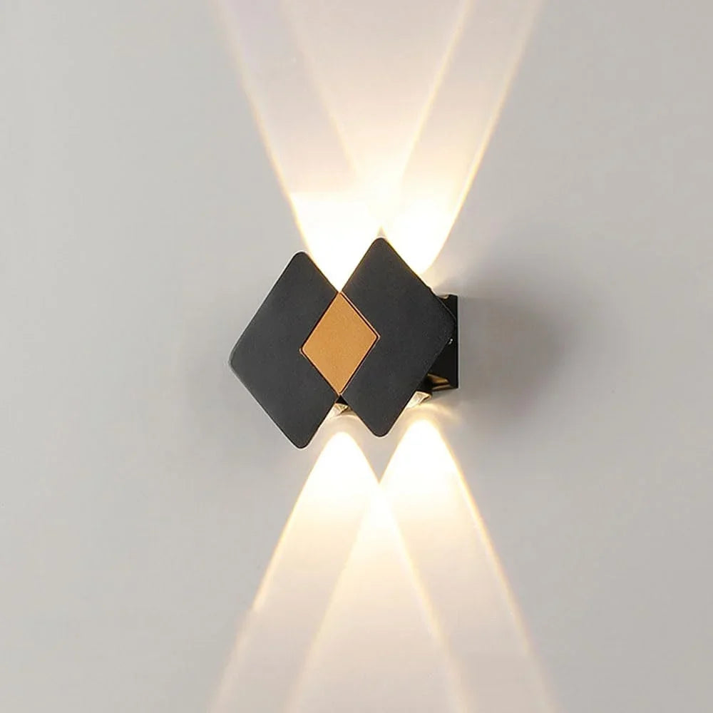 Modern black and gold wall sconce with upward and downward lighting, ideal for contemporary interior decor.
