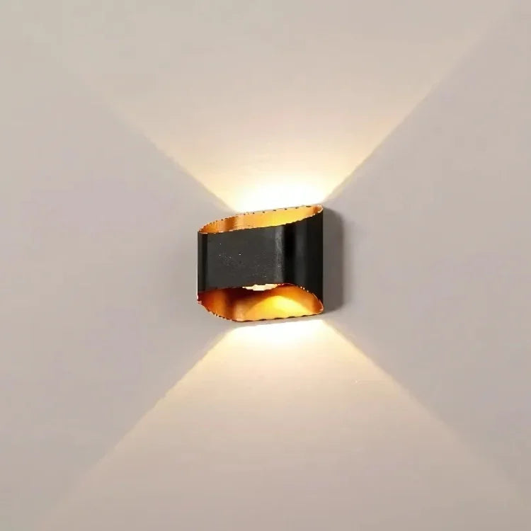 Modern black and gold wall sconce with upward and downward lighting for contemporary interior decor