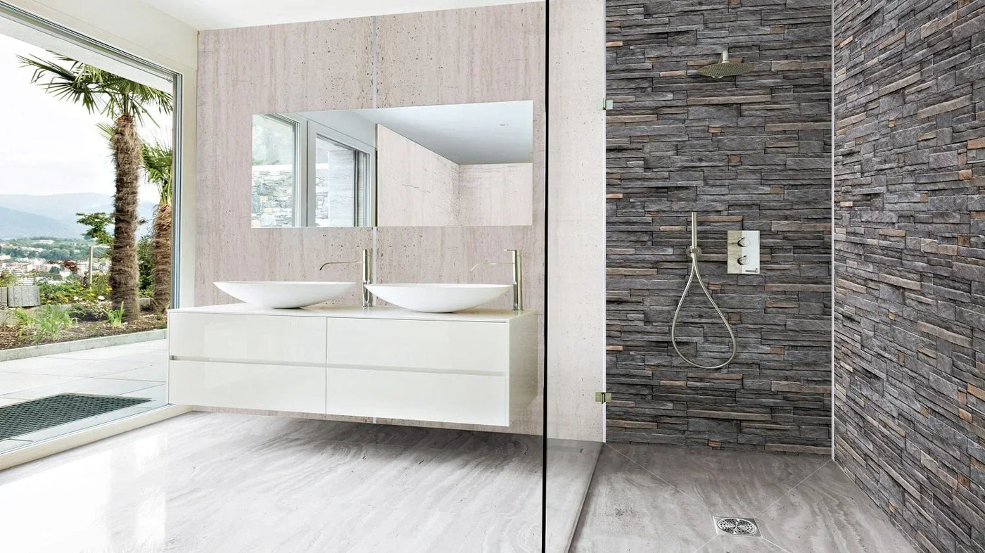 Modern bathroom with sleek white vanity, stone-look shower wall, and large window view