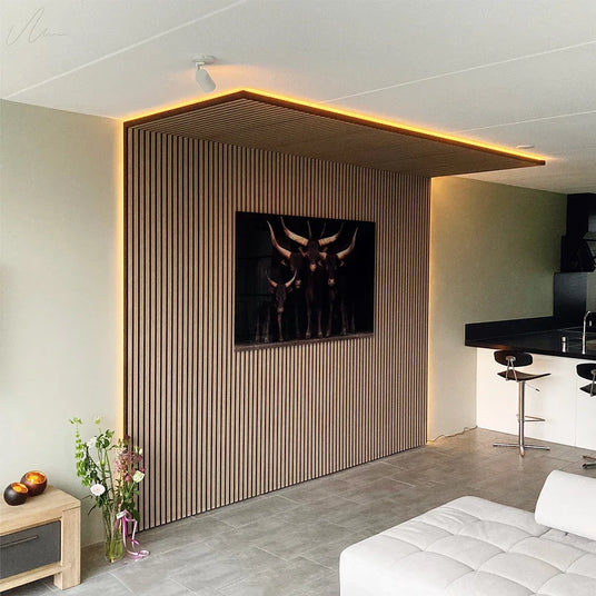 Modern living room with wooden slat wall paneling, LED lighting, and framed bull artwork for acoustic decor.